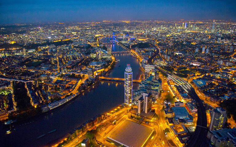 Aerial photo of London at night, featuring The Tower, One St George Wharf and Nine Elms regeneration area in the foreground.